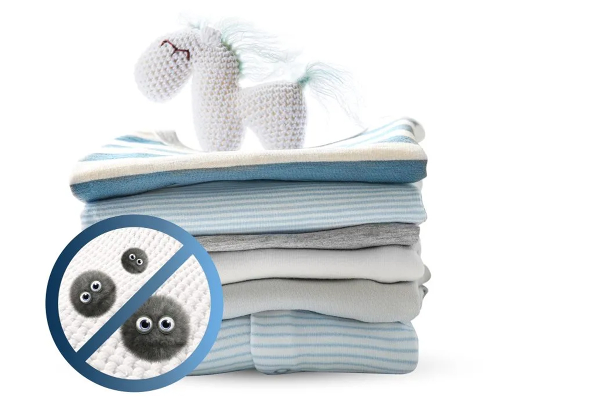 Απεικονίζονται μια στοίβα από ρούχα, ένα παιδικό παιχνίδι και ένα σύμβολο που δηλώνει ότι δεν υπάρχουν μικρόβια.